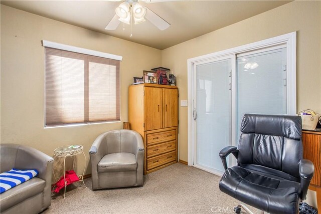 living area with ceiling fan and light carpet