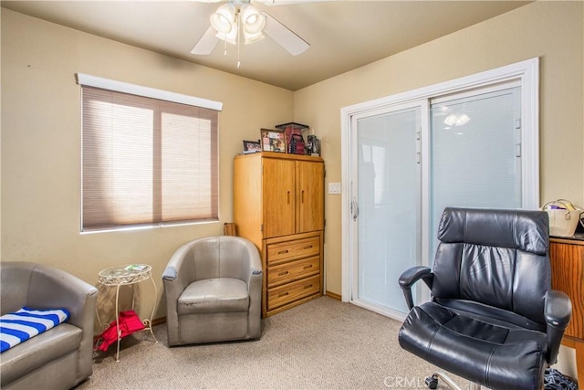 living area with light colored carpet and ceiling fan