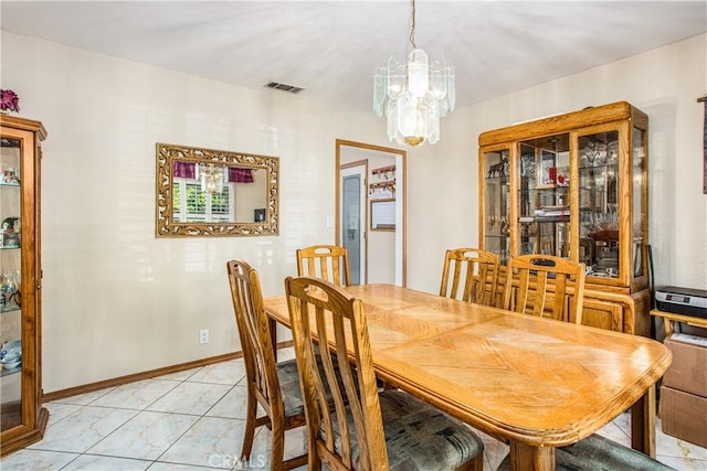 tiled dining room with a chandelier