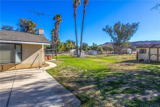 view of yard featuring a storage shed and a mountain view