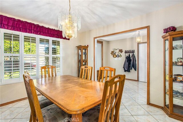 tiled dining room with a notable chandelier