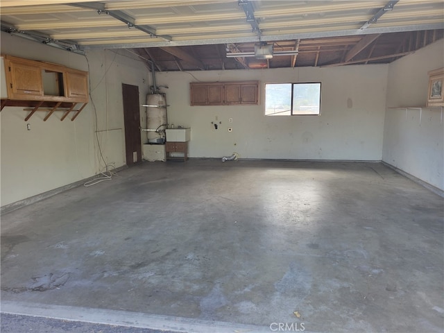 garage with a garage door opener, sink, and secured water heater