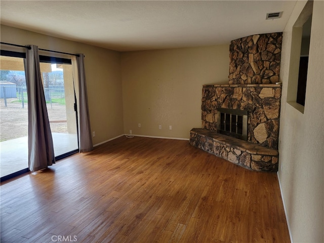 unfurnished living room with a fireplace and hardwood / wood-style floors