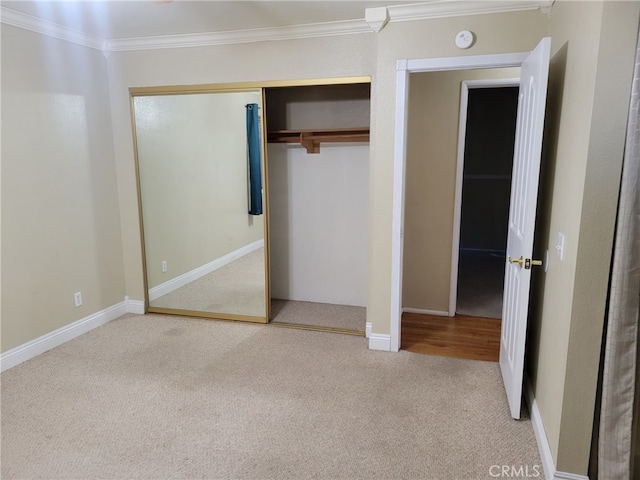 unfurnished bedroom with crown molding, carpet floors, and a closet