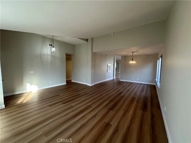 unfurnished living room featuring dark hardwood / wood-style flooring and an inviting chandelier