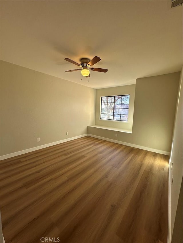 empty room featuring ceiling fan and dark hardwood / wood-style flooring