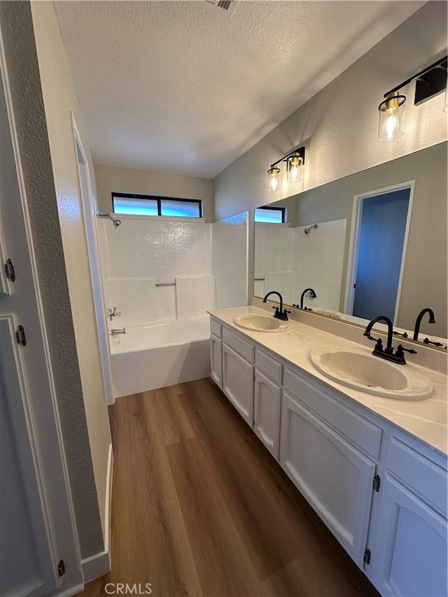 bathroom featuring a textured ceiling, independent shower and bath, hardwood / wood-style floors, and vanity