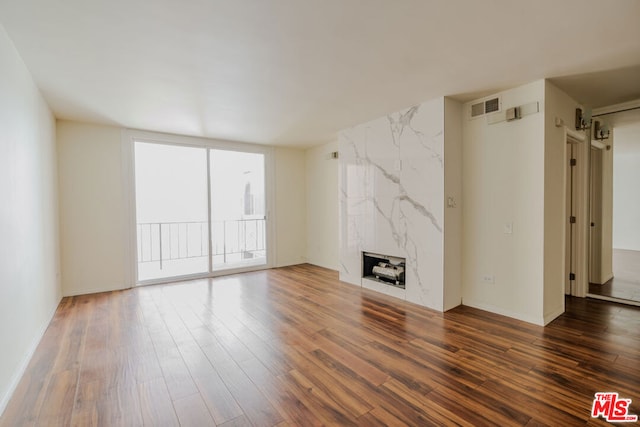 unfurnished living room with dark wood-type flooring and a fireplace