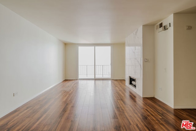 unfurnished living room with a fireplace, floor to ceiling windows, and dark hardwood / wood-style floors