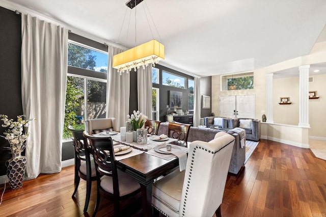 dining room with ornate columns and hardwood / wood-style flooring