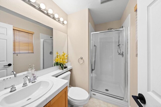 bathroom featuring toilet, an enclosed shower, tile patterned flooring, and vanity