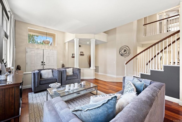 living room with decorative columns and hardwood / wood-style flooring