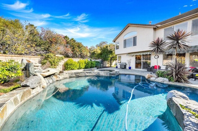 view of pool with an in ground hot tub