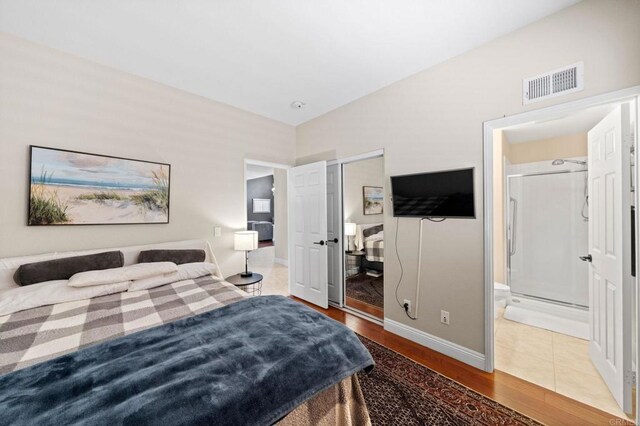 bedroom with ensuite bathroom and wood-type flooring