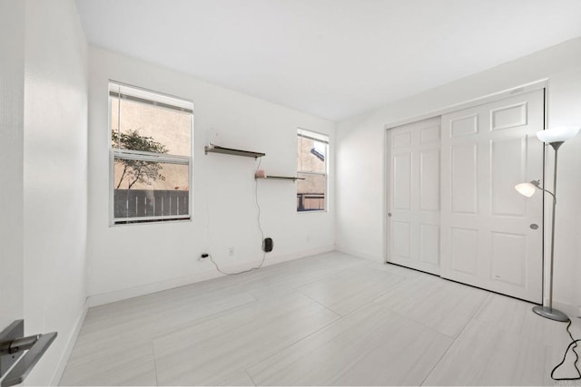 unfurnished bedroom featuring a closet and multiple windows