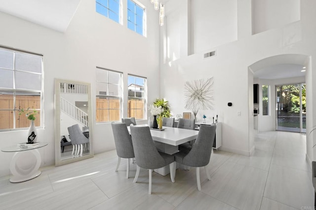 tiled dining area with a high ceiling