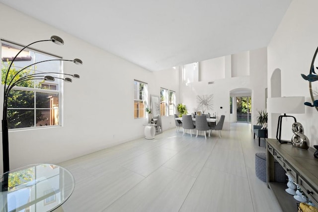 tiled living room featuring a high ceiling and a healthy amount of sunlight