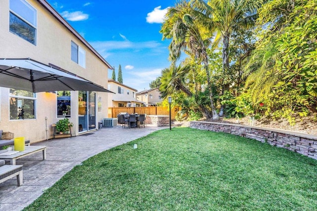 view of yard with central AC unit and a patio