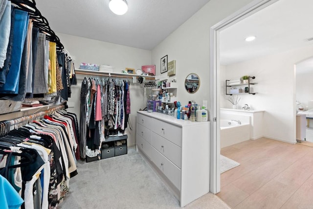 walk in closet featuring light colored carpet