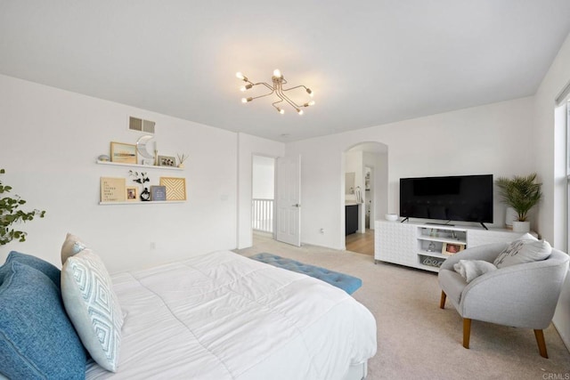 carpeted bedroom featuring an inviting chandelier