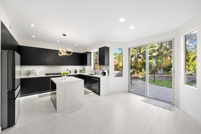 kitchen featuring dishwasher, refrigerator, pendant lighting, a center island, and sink