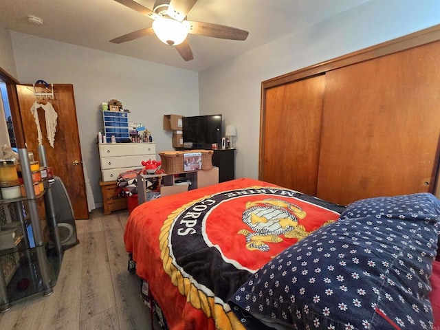 bedroom with ceiling fan, light hardwood / wood-style flooring, and a closet