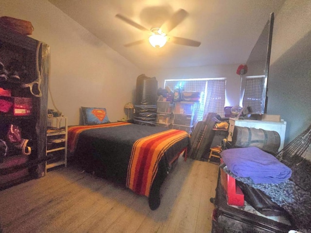 bedroom with ceiling fan, lofted ceiling, and hardwood / wood-style floors