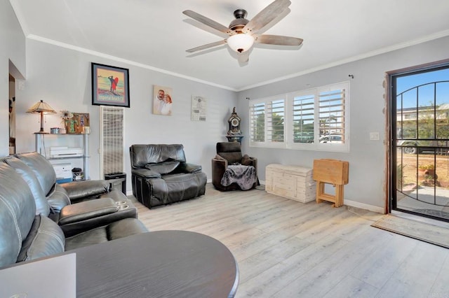 living room featuring ceiling fan, plenty of natural light, ornamental molding, and light wood-type flooring