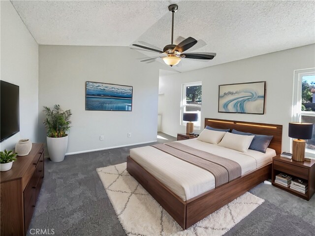 bedroom with dark carpet, a textured ceiling, ceiling fan, and vaulted ceiling