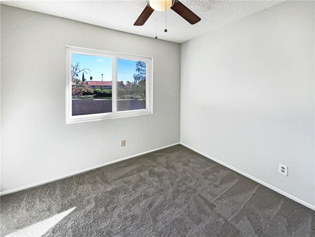 carpeted spare room featuring a textured ceiling and ceiling fan