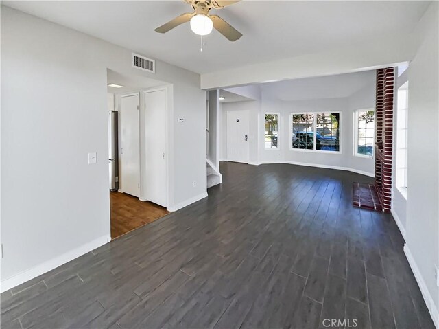 unfurnished living room with dark hardwood / wood-style flooring and ceiling fan