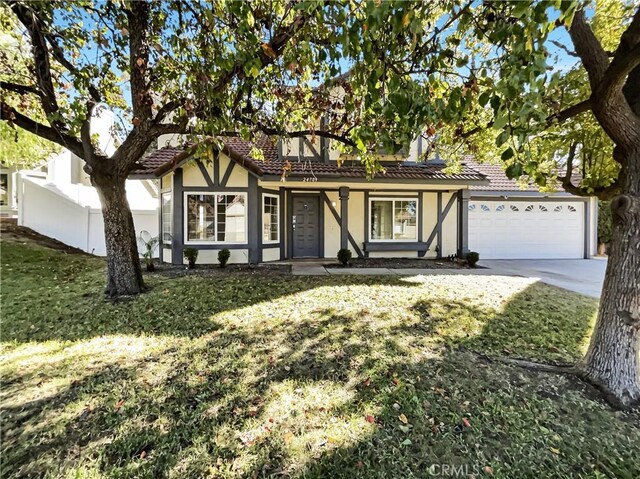 english style home with a front lawn and a garage