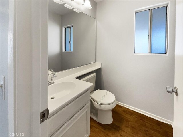 bathroom featuring toilet, vanity, and hardwood / wood-style flooring