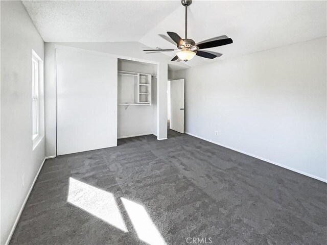 unfurnished bedroom with vaulted ceiling, ceiling fan, a closet, and multiple windows