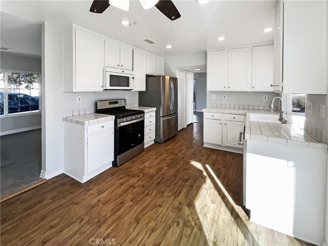 kitchen featuring sink, white cabinetry, tile countertops, and appliances with stainless steel finishes