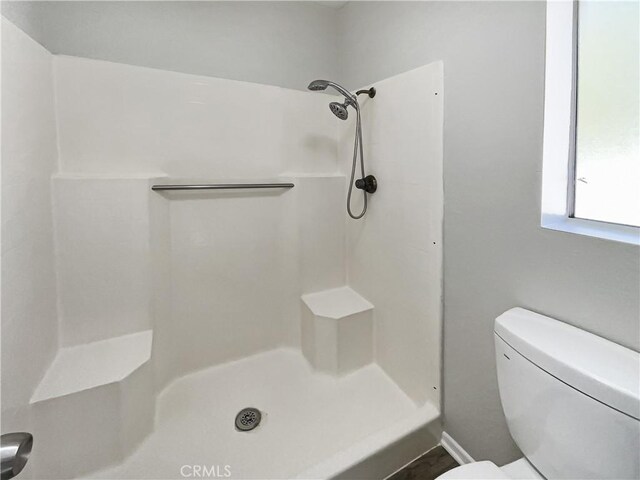 bathroom featuring a shower and toilet