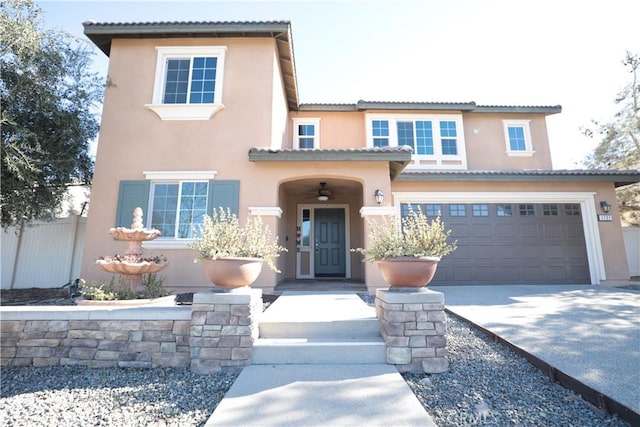 mediterranean / spanish home featuring fence, a garage, stucco siding, a tile roof, and concrete driveway