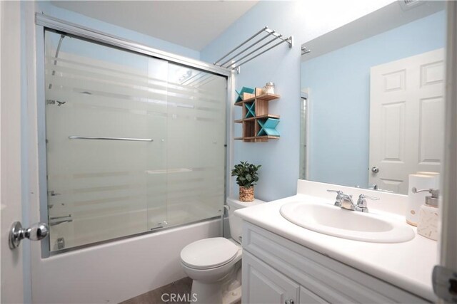 full bathroom featuring vanity, combined bath / shower with glass door, and toilet