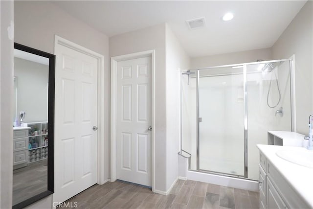 full bath featuring wood finished floors, visible vents, a shower stall, vanity, and recessed lighting