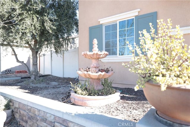 view of side of property featuring stucco siding and fence