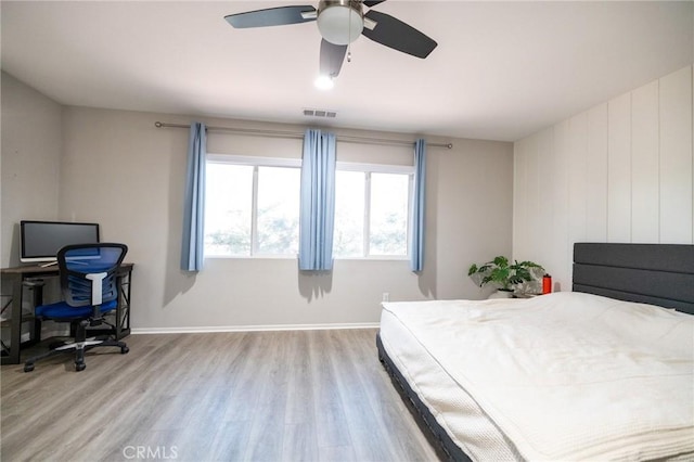 bedroom with baseboards, ceiling fan, light wood finished floors, and visible vents