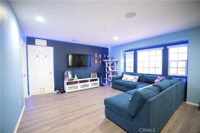 living area featuring baseboards, recessed lighting, and wood finished floors