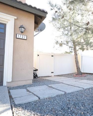 entrance to property with stucco siding and fence