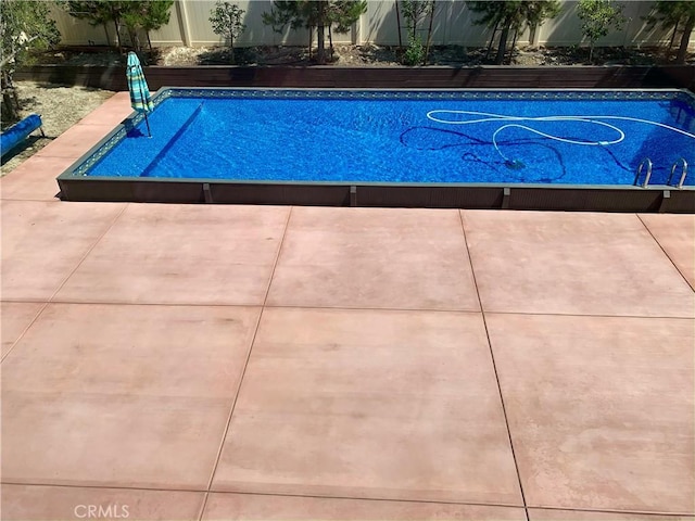 view of swimming pool featuring fence and a fenced in pool