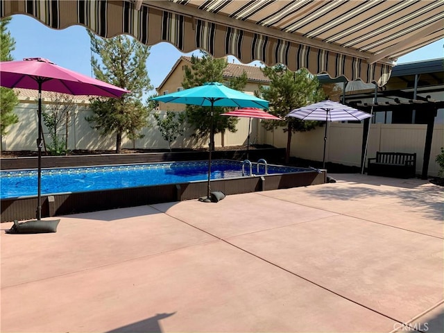 view of swimming pool featuring a fenced backyard, a patio, and a fenced in pool