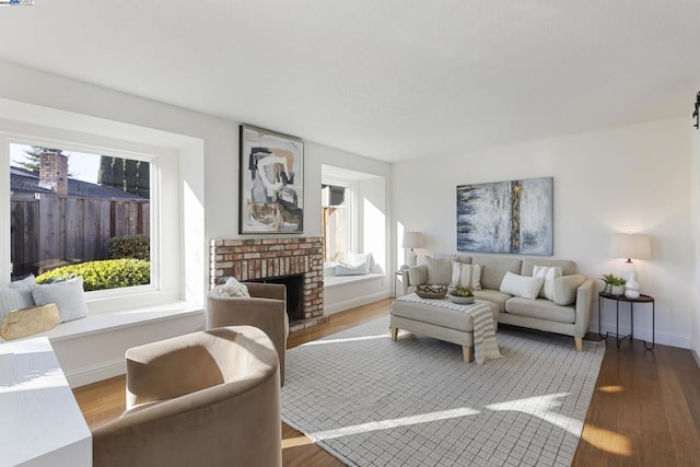 living room with a brick fireplace and light hardwood / wood-style floors