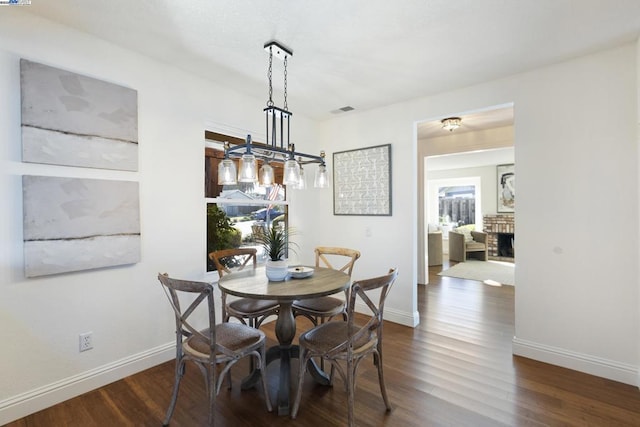 dining space featuring dark hardwood / wood-style flooring and a fireplace