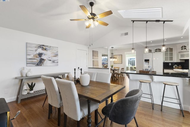 dining space with ceiling fan, lofted ceiling, and dark hardwood / wood-style floors