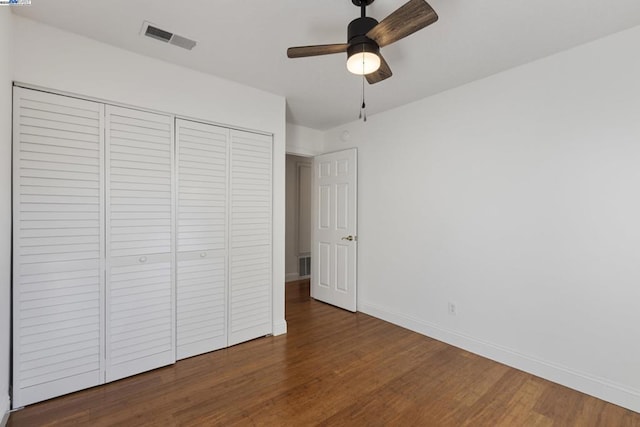 unfurnished bedroom with ceiling fan, dark hardwood / wood-style flooring, and a closet