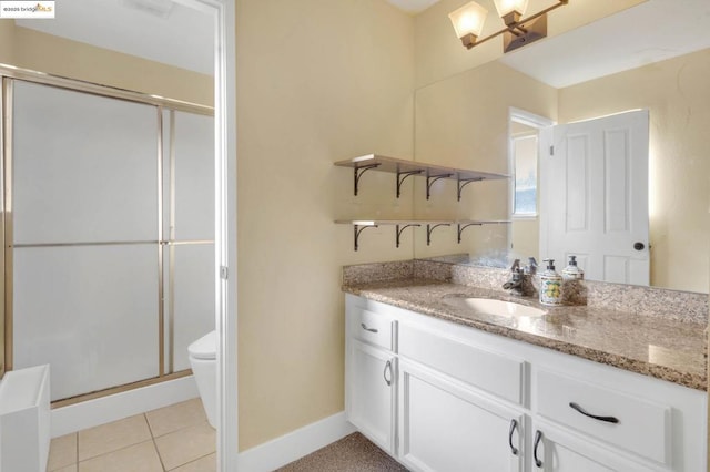 bathroom with toilet, tile patterned flooring, a shower with shower door, and vanity